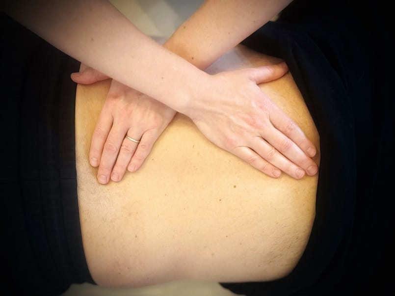 A doctor’s hands skillfully apply Myofascial Release techniques on a patient's back, enhancing comfort and well-being.